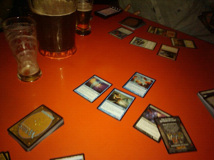 Magic the gathering cards and beer over a table